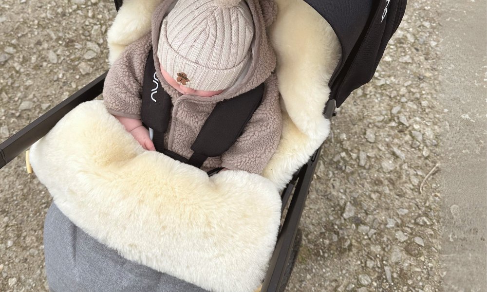 sheepskin pram footmuff in the sun with baby