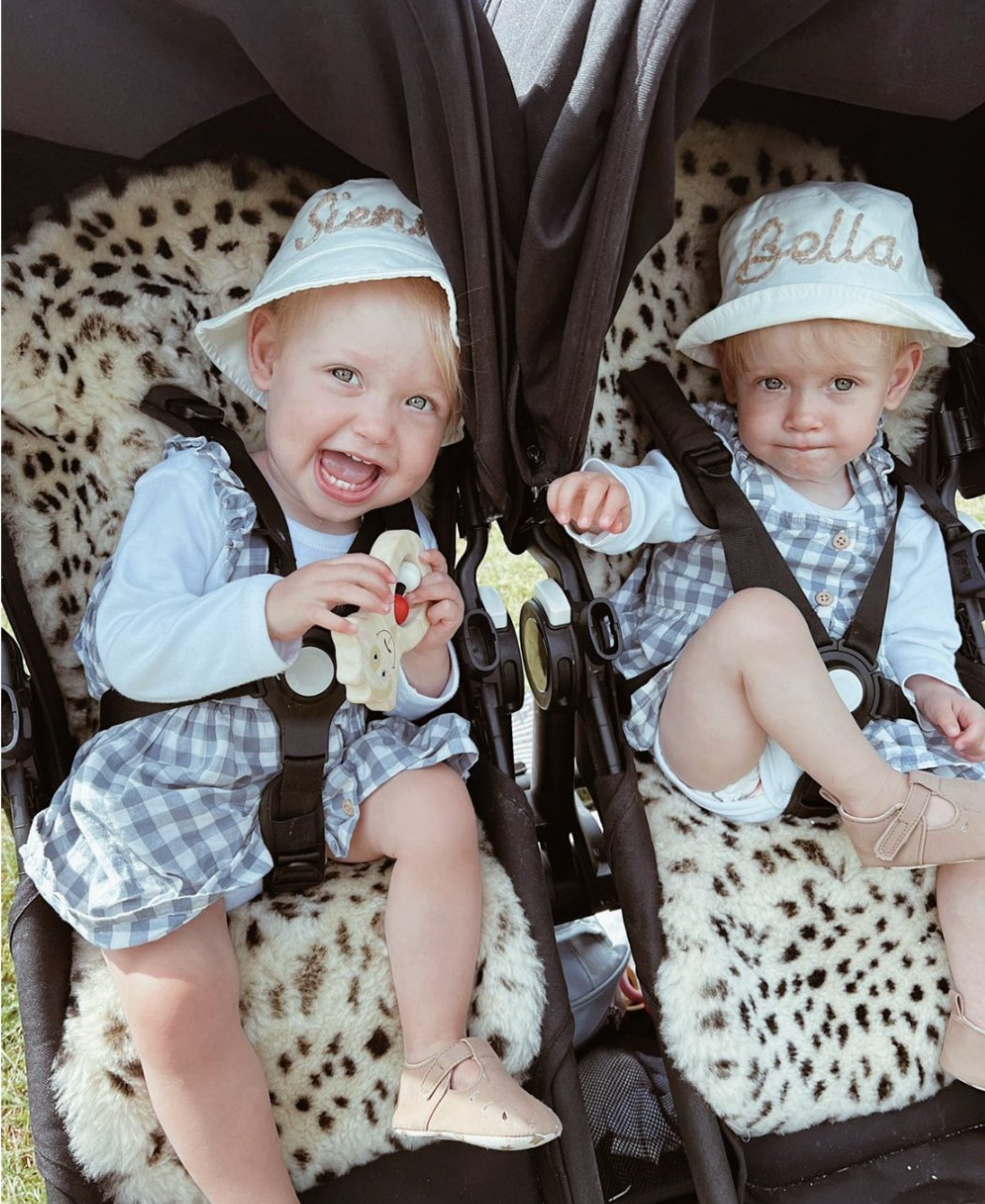 Two happy toddlers enjoying a ride in their cosy sheepskin buggy liners.