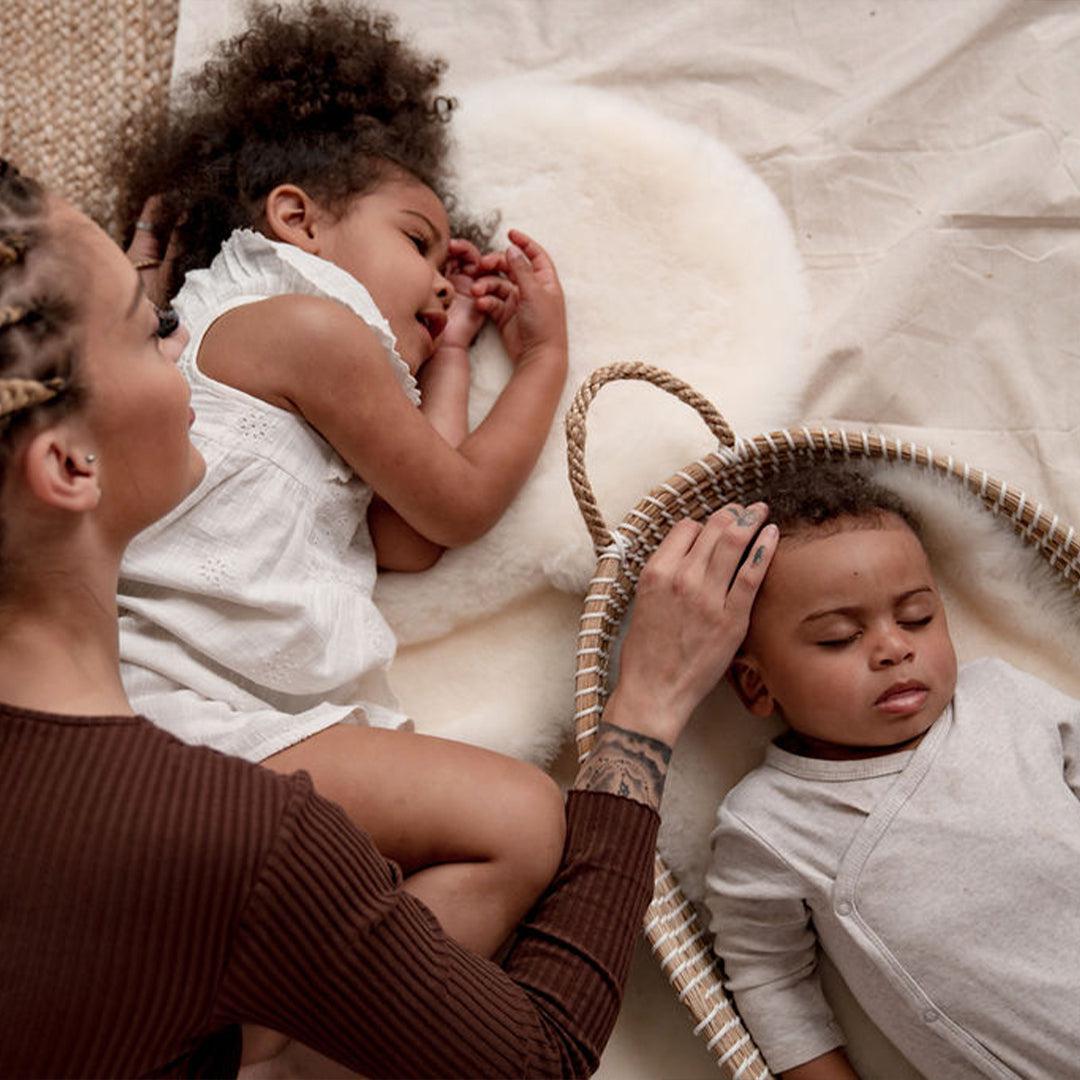 baby sleeping on sheepskin moses basket liner