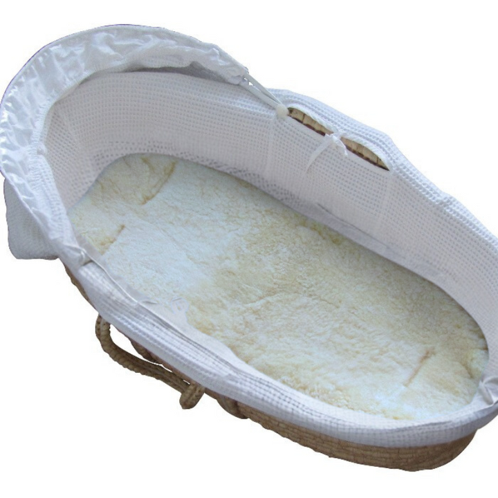 White carrycot liner made of sheepskin to help a newborn sleep