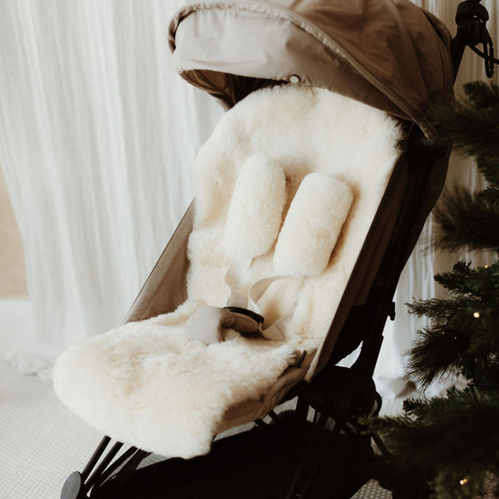 Sheepskin buggy liner in a neutral milk shade in a Babyzen yoyo pram with matching harness covers for the straps