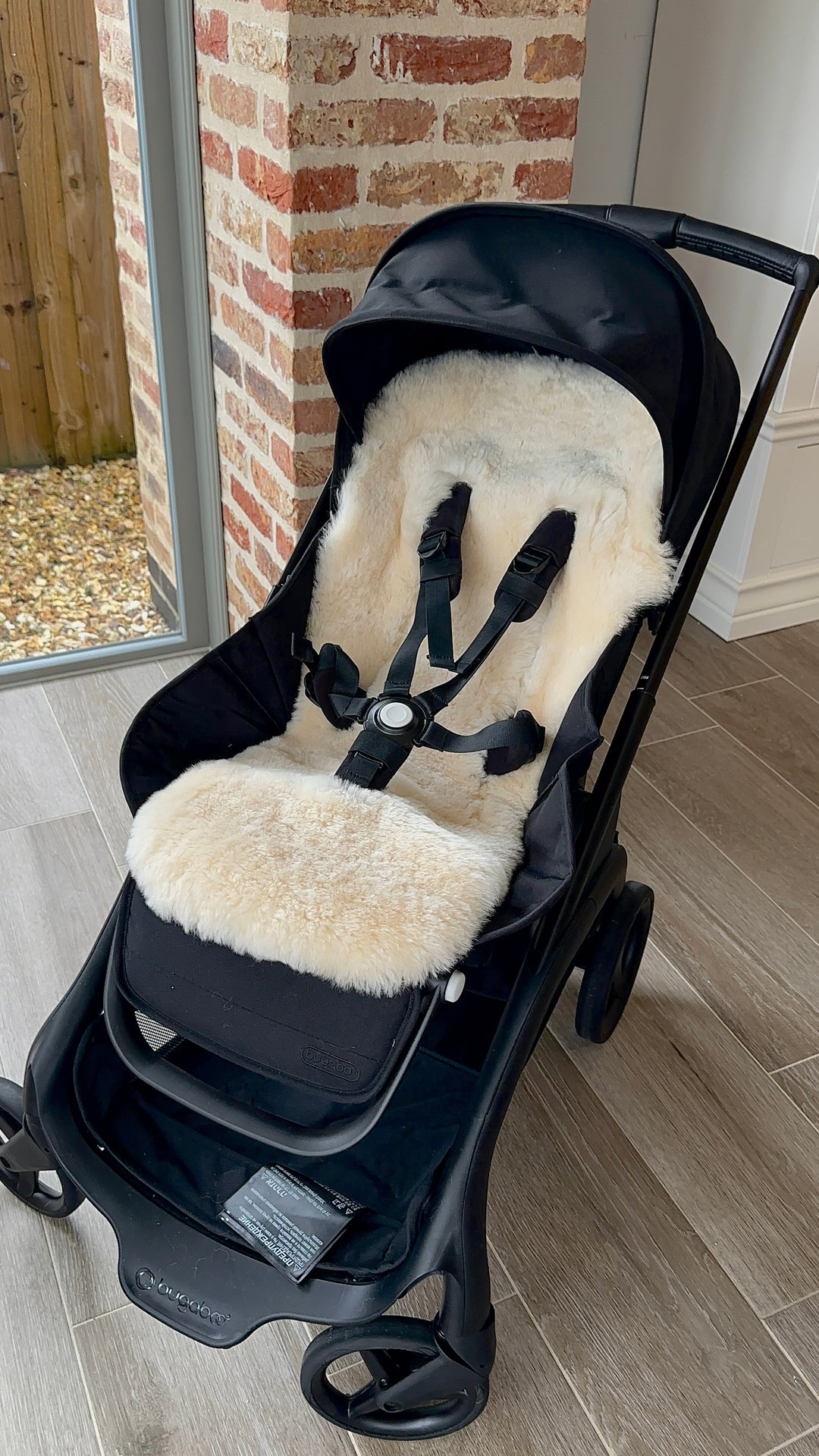 Sheepskin buggy style snuggler liner in a bugaboo dragonfly pram showing perfect fitting with the harness