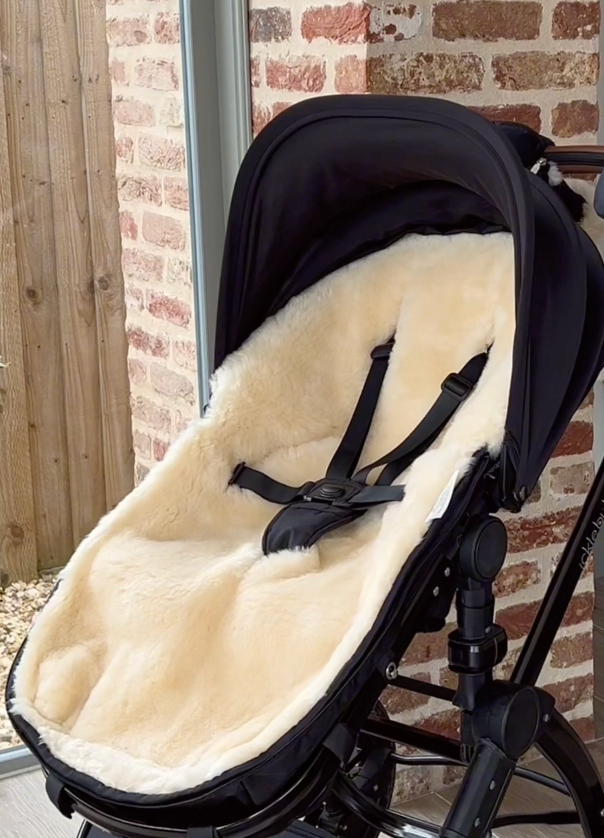 Sheepskin footmuff with the top zipped off to show a layer of sheepskin underneath which acts as a pram liner in the warmer months