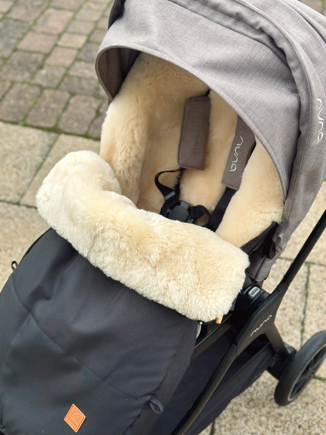 Breathable sheepskin pram footmuff showing the fit in a Nuna Tric city pram 