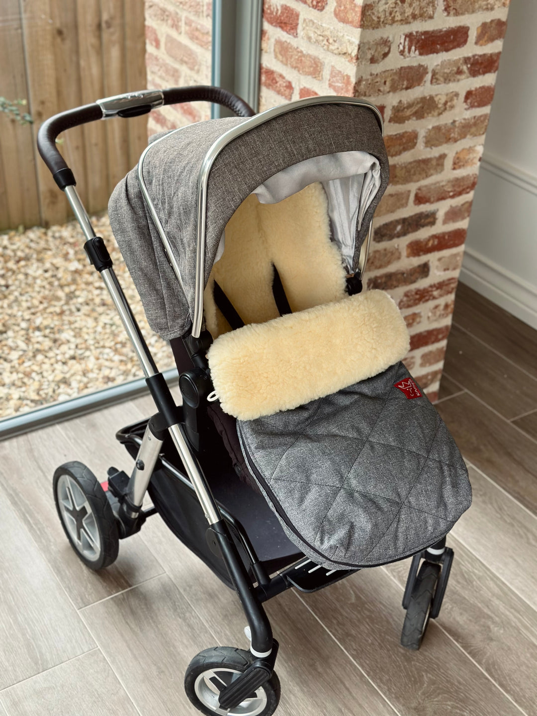 Kasier Natura sheepskin pram footmuff shown in a silver cross stroller to help keep baby warm in winter