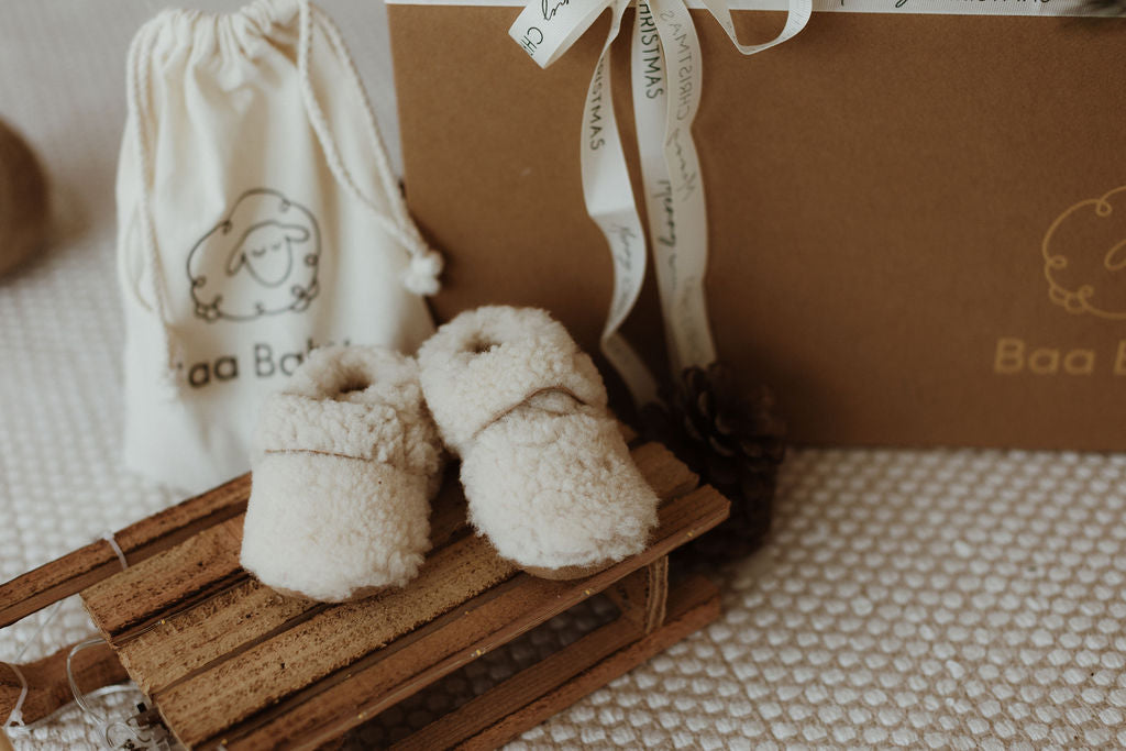 Natural and sustainable neutral oat shaded merino sheepskin baby booties with straps to secure them