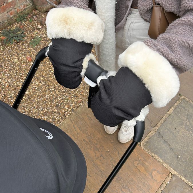 sheepskin gloves for pram and stroller shown on the handlebars of a bugaboo fox 5 buggy