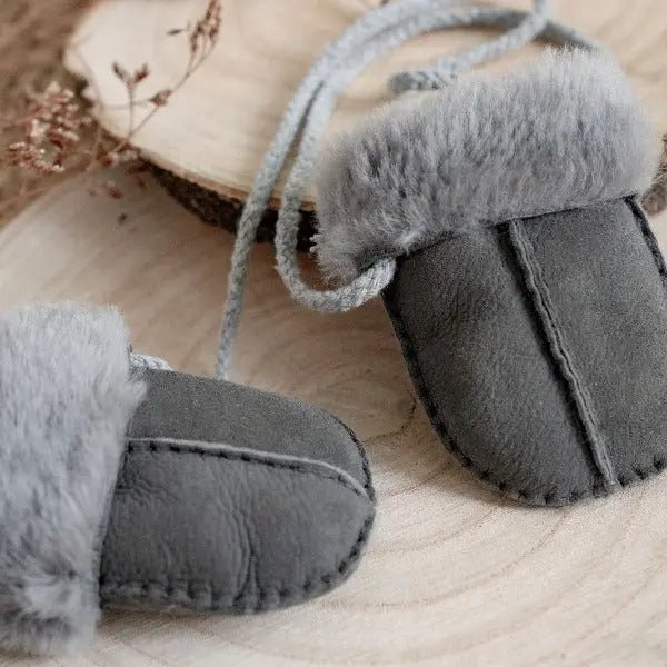 Grey mittens on string with a sheepskin liningfor babies and toddlers 