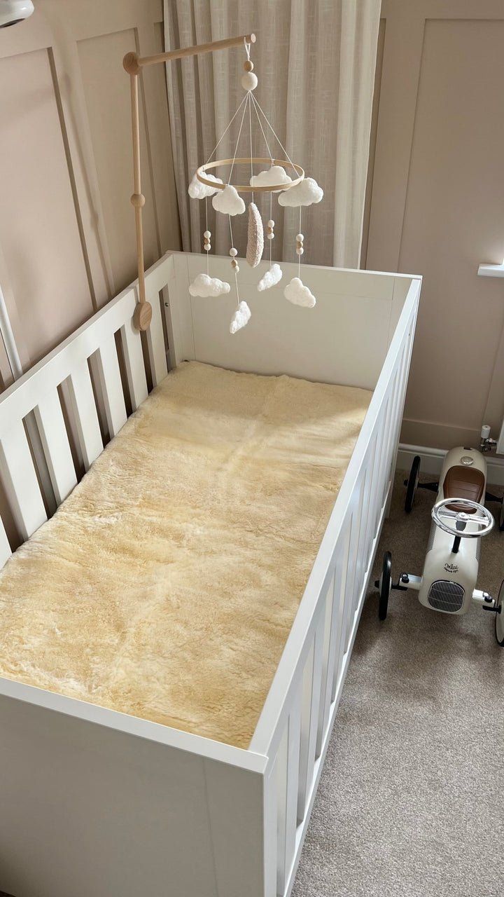 Fellhof sheepskin mattress cover for a cot or junior bed, bed pad and comforter and topper for a baby crib to help settle baby to sleep