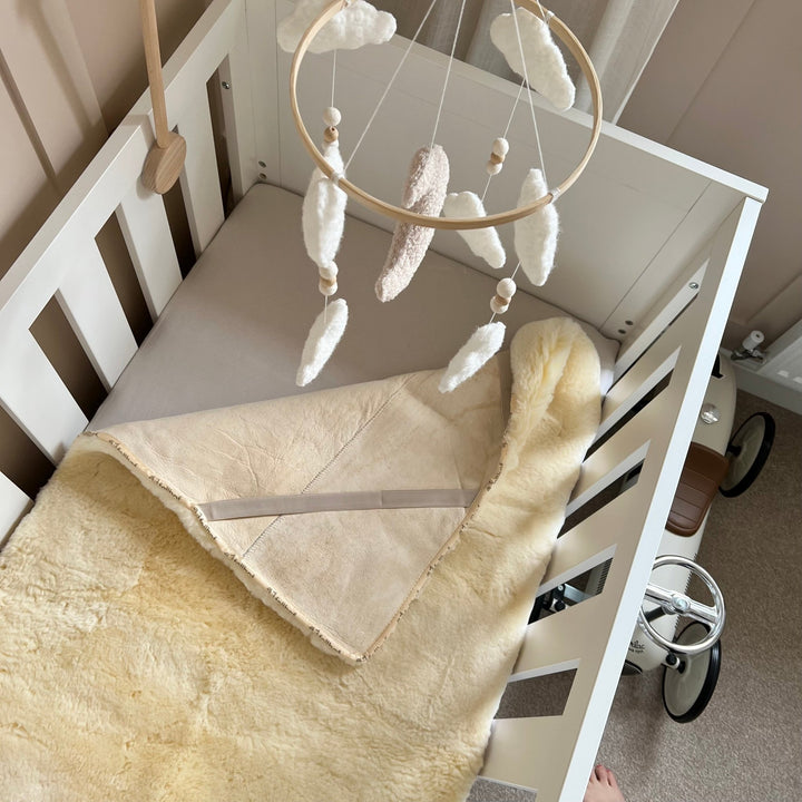 Natural sheepskin cot topper to settle and help a baby sleep from fellhof - pale soft honey lambskin with breathability