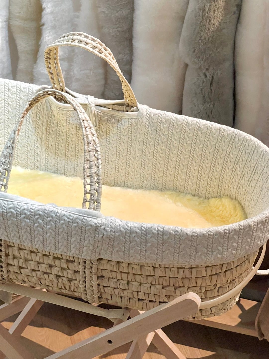 Natural honey coloured sheepskin carrycot liner shown in a moses basket to keep a newborn comforable and settled