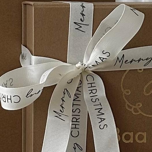 Christmas ribbon in neutral cream and luxury weave shown wrapped around a  gift box for a newborn present