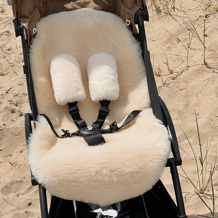 Babyzen yoyo pram with sheepskin pram liner in pale neutral milk tone with additional pram harness strap covers made from natural merino