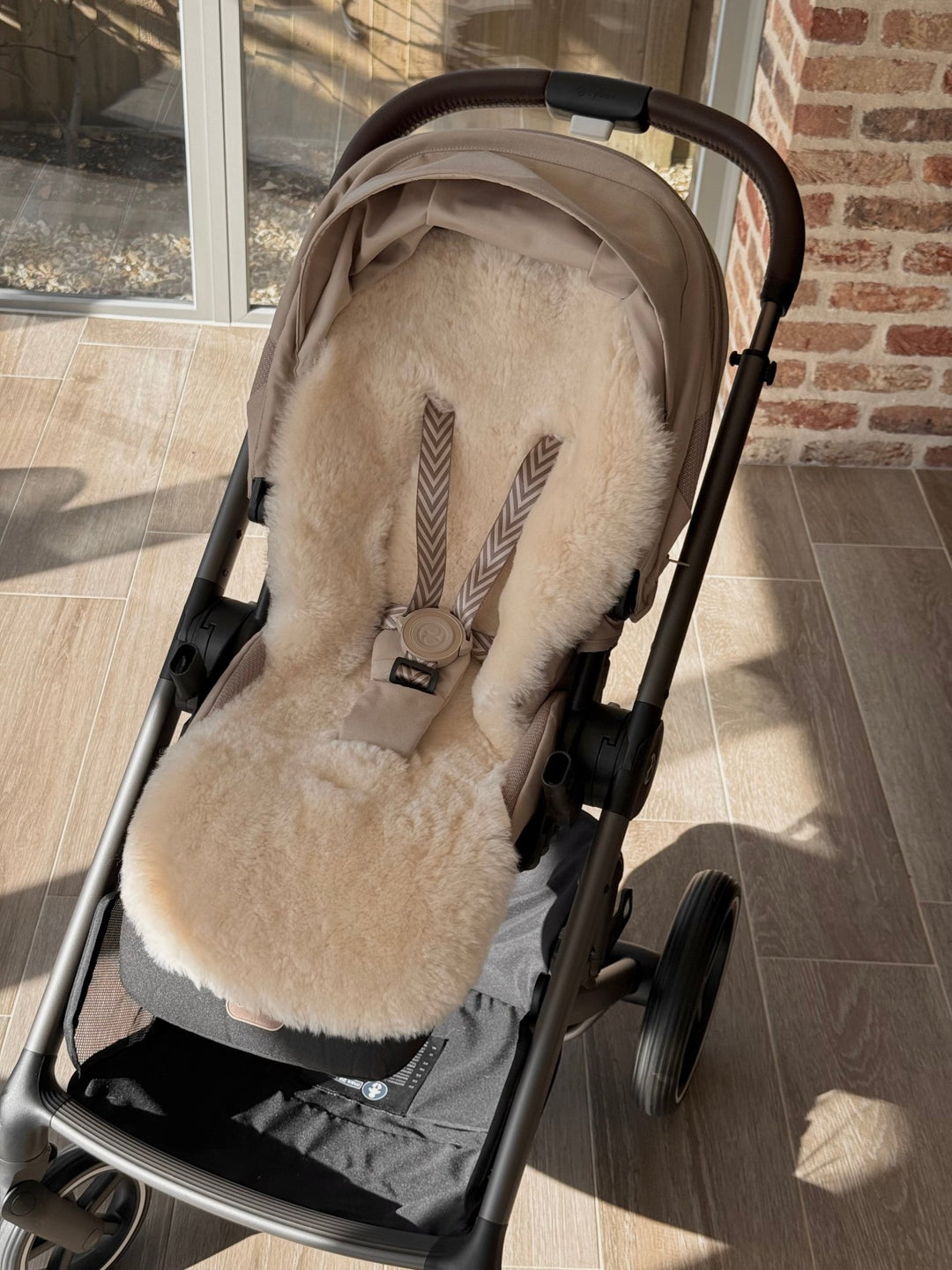 Cybex balios with a baa baby sheepskin snuggle liner in neutral milk colour with fixed harness pram