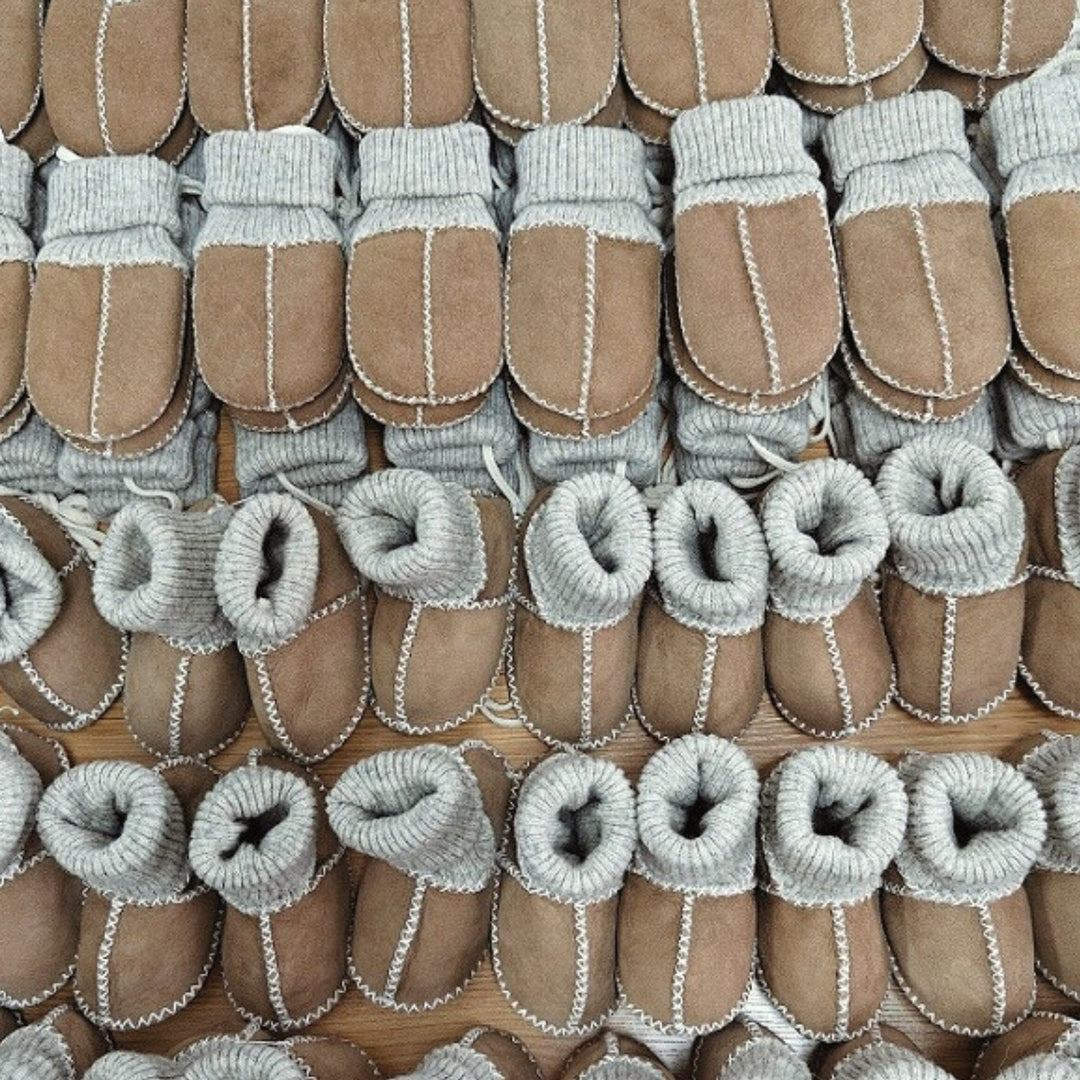 Sheepskin sock booties and mittens in a neutral beige and caramel colour.  Mittens are held together with a string and suitable for babies and toddler